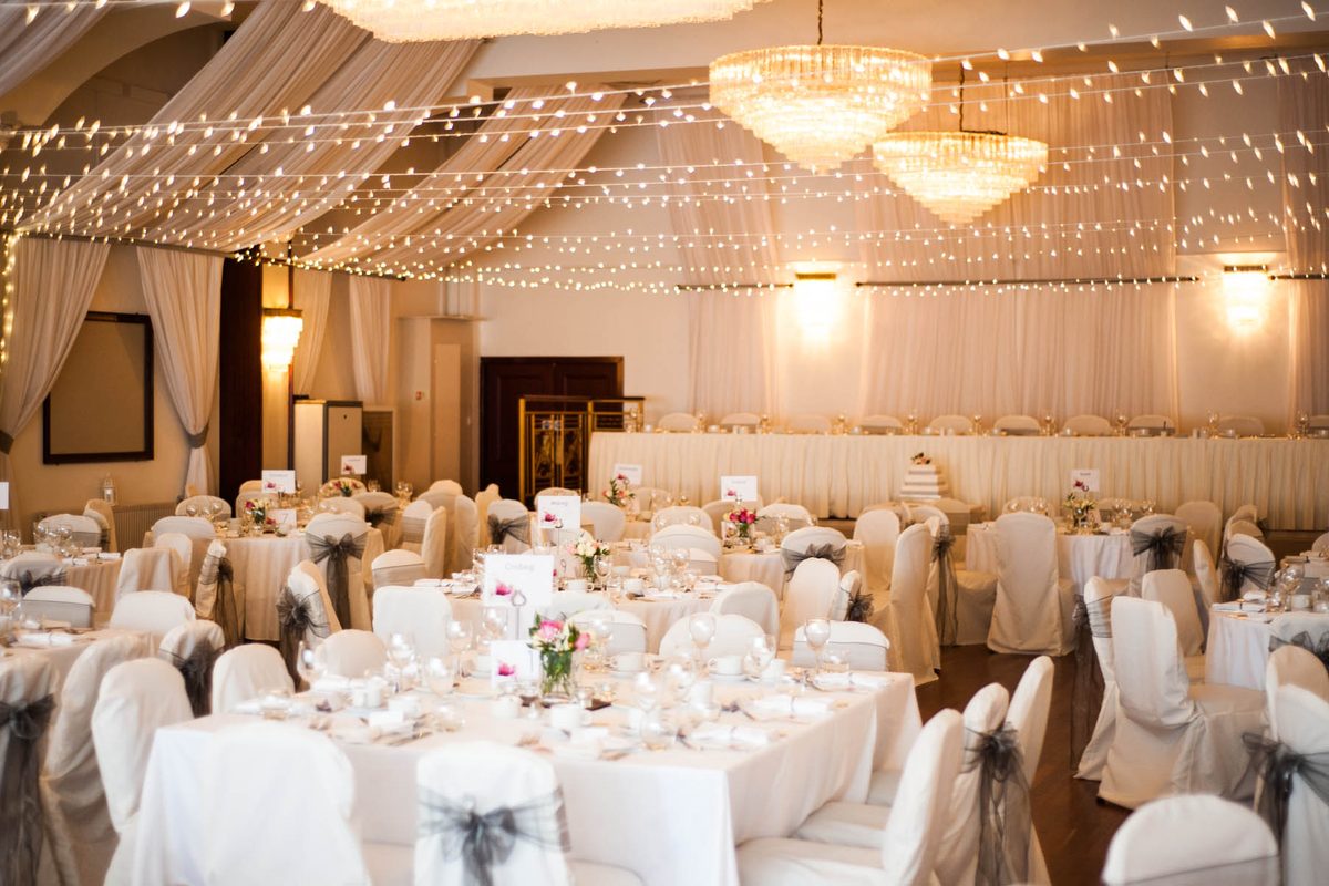 Caberfeidh Hotel ballroom set for a wedding reception with fairy lights and chandeliers, Stornoway