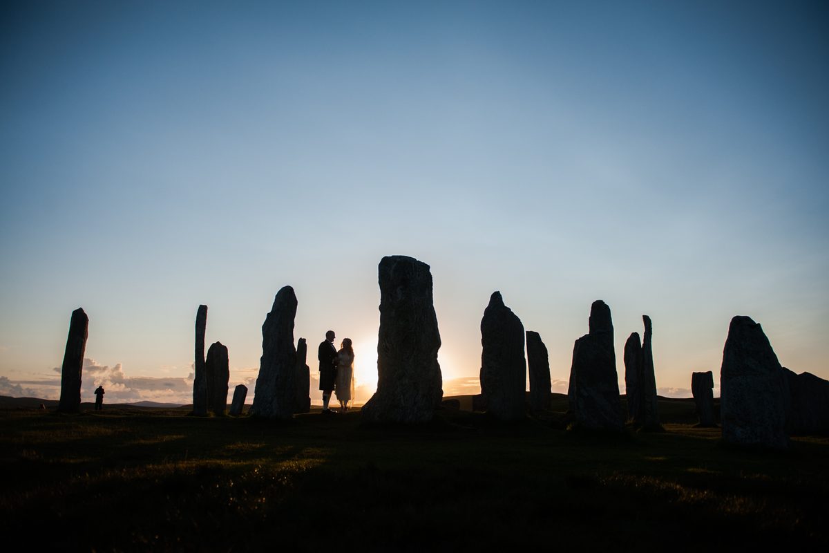 Couple silhouetted among the Callanish Standing Stones at sunset, Isle of Lewis