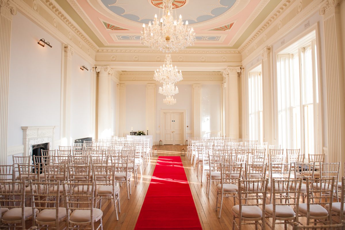 Ceremony room at Lews Castle with chandeliers, white chairs and a red aisle, Stornoway