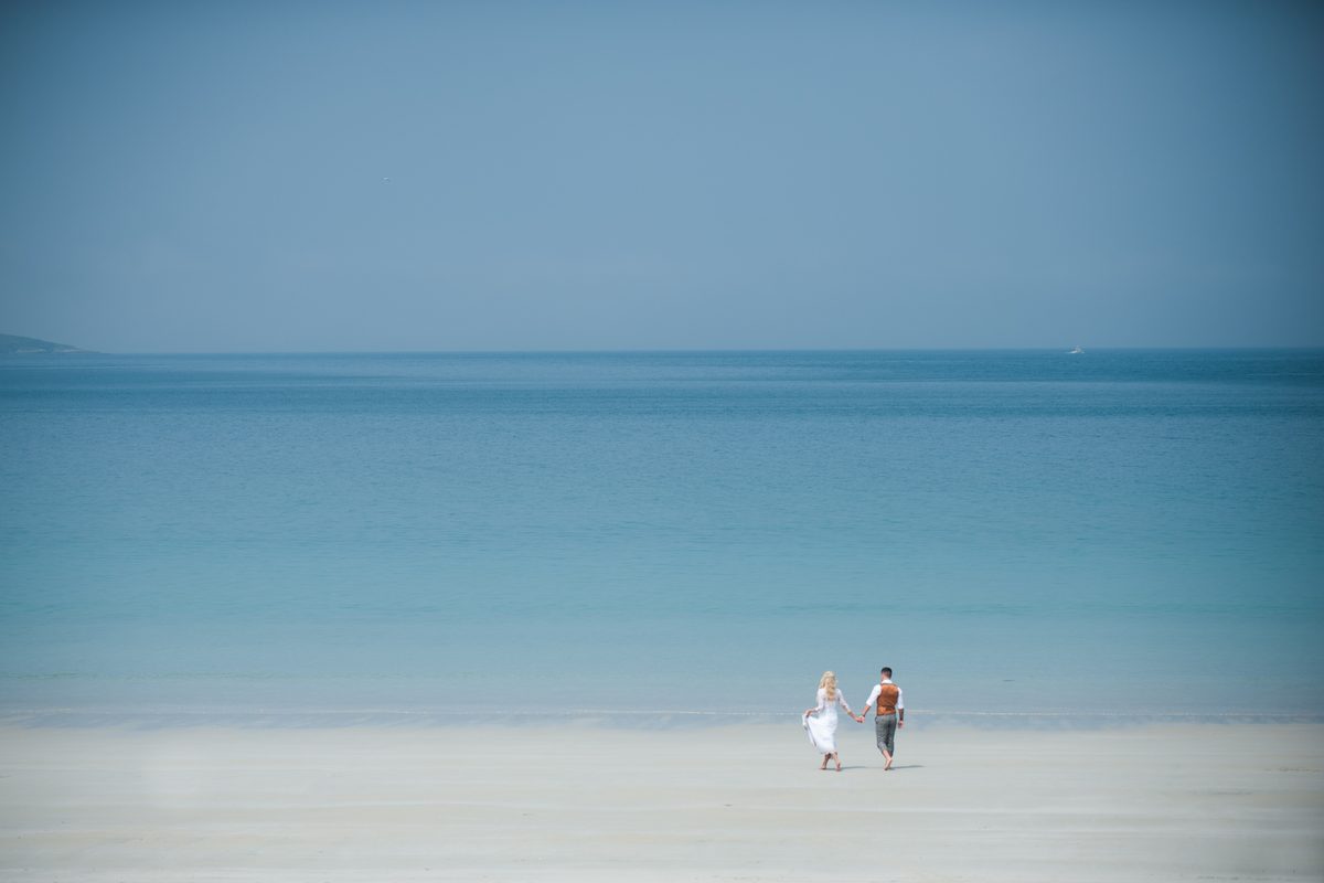 Bride and groom walking on the white sands of Luskentyre beach, Isle of Harris